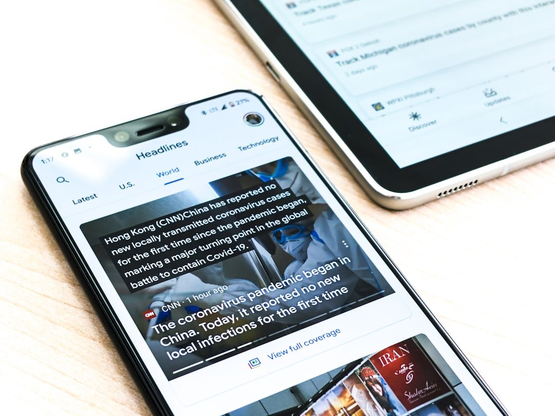 Home A Google pixel 3XL showing Covid-19 information from the Google News app sits on a wooden table next to a Samsung Galaxy Tablet.